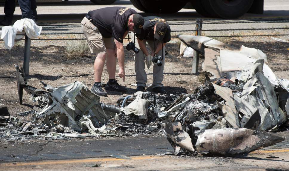 Rick Egan  |  The Salt Lake Tribune
CSI investigators sort through the debris from the plane crash that killed four people in the median of I-15 freeway, around 1:00 p.m. The crash closed the freeway to northbound traffic on Wednesday.