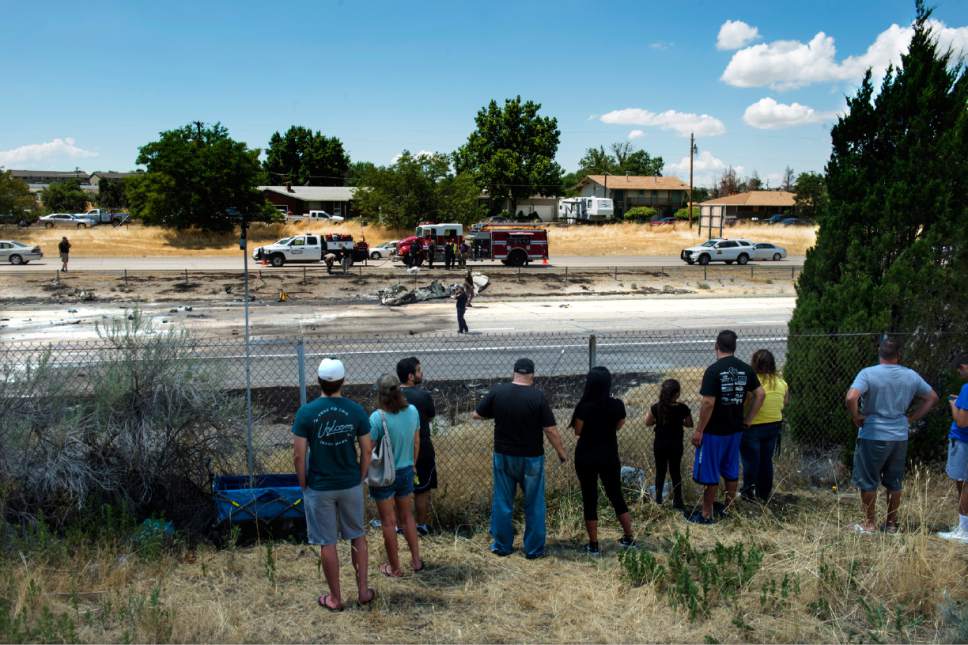 Rick Egan  |  The Salt Lake Tribune

Curious on-lookers watch as the police investigate the plane crash that killed four people in the median of I-15 freeway, around 1:00pm. The crash closed the freeway to northbound traffic, Wednesday, July 26, 2017.