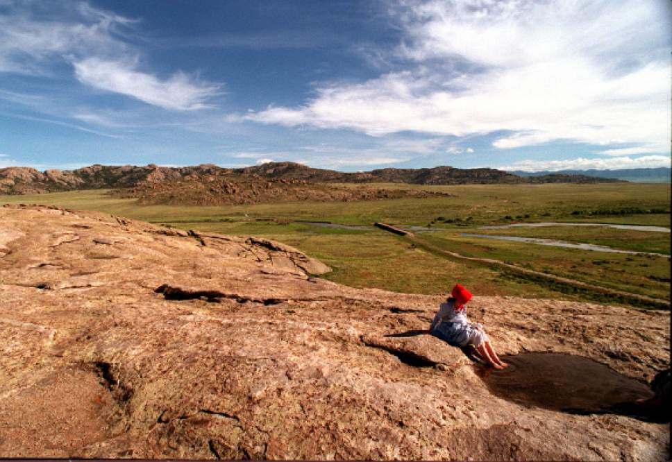 Rick Egan  |  Tribune file photo 
Jessica Hess, 14, of Star Valley, Wyoming, soaks her feet in a puddle of water on top of Independence Rock after pulling a handcart all day.
