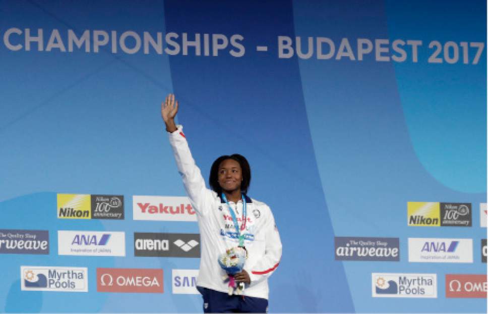 United States' Simone Manuel celebrates on the podium after winning the gold medal in the women's 100-meter freestyle final during the swimming competitions of the World Aquatics Championships in Budapest, Hungary, Friday, July 28, 2017. (AP Photo/Michael Sohn)