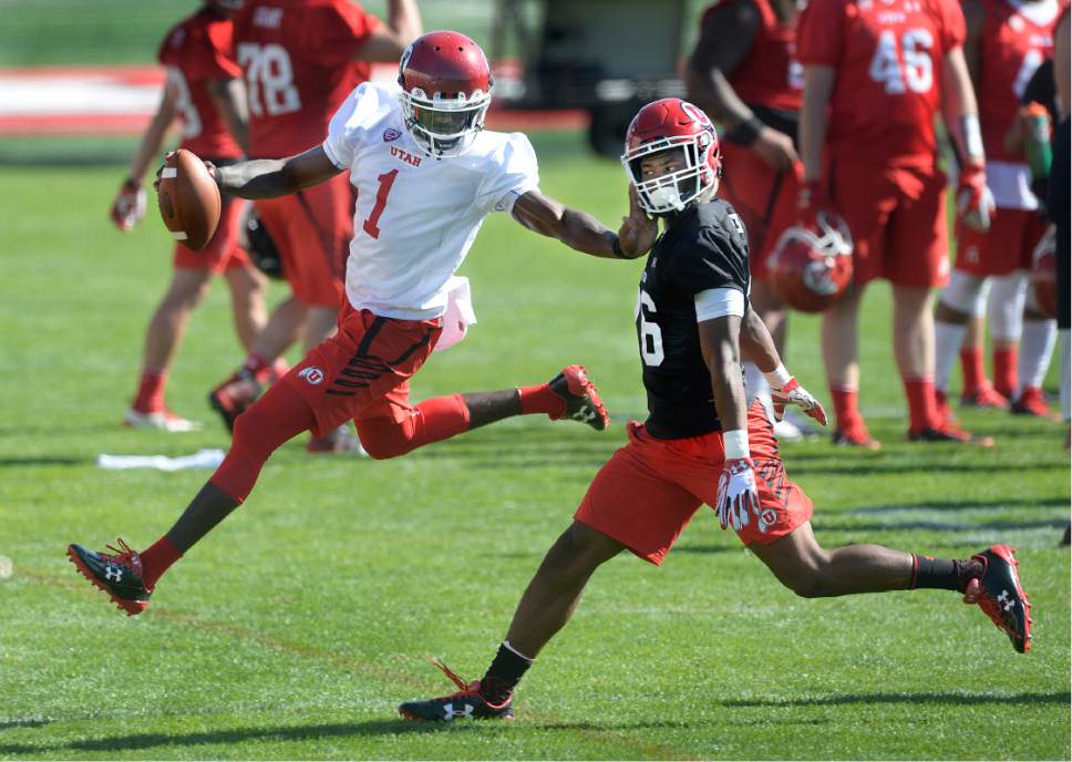 Scott Sommerdorf   |  The Salt Lake Tribune  
Utah QB Tyler Huntley stiff arms DB Terrell Burgess during the first day of Utah fall football camp, Friday, July 28, 2017.